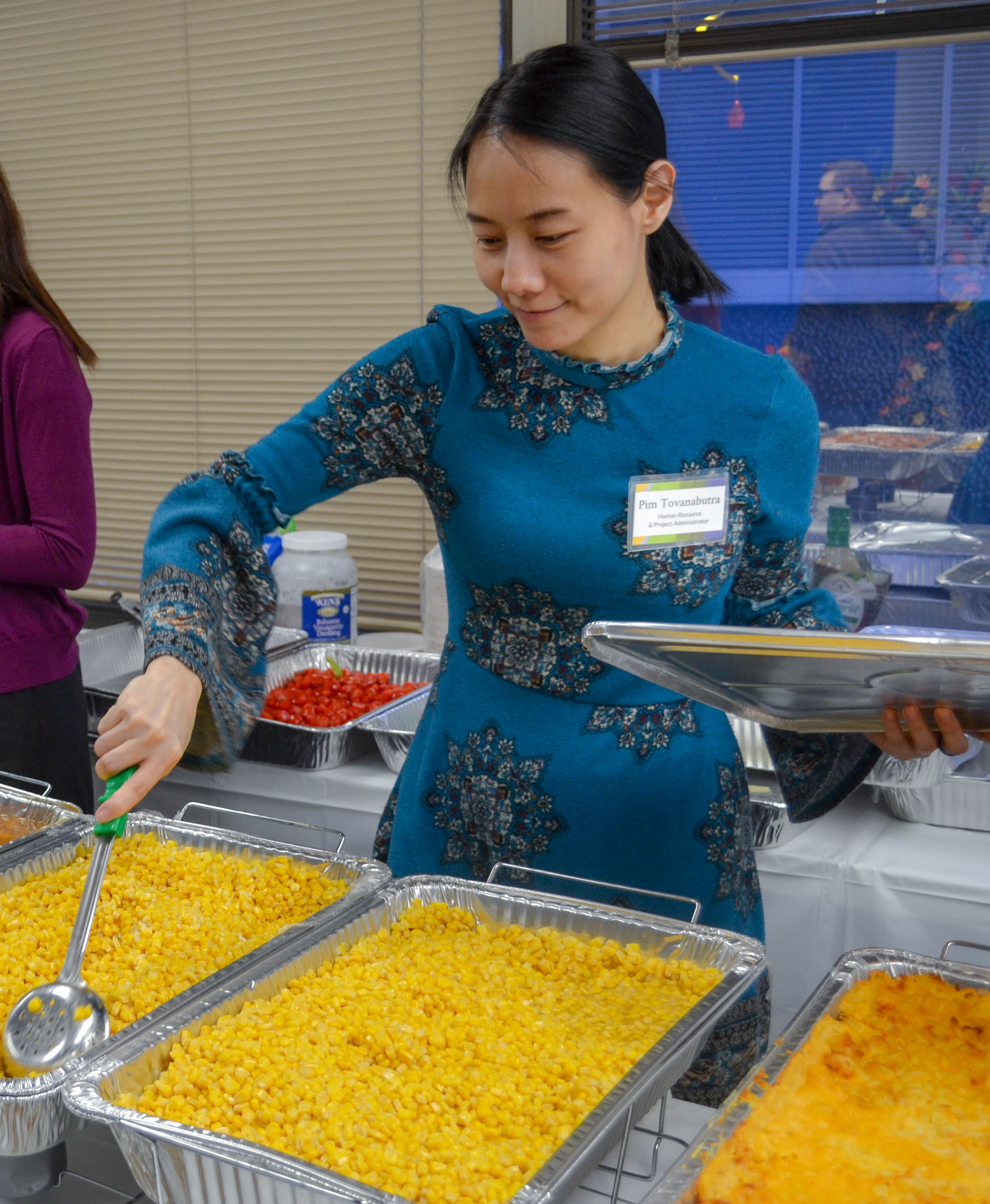 Staff member serves corn at DLS Thanksgiving celebration 2018