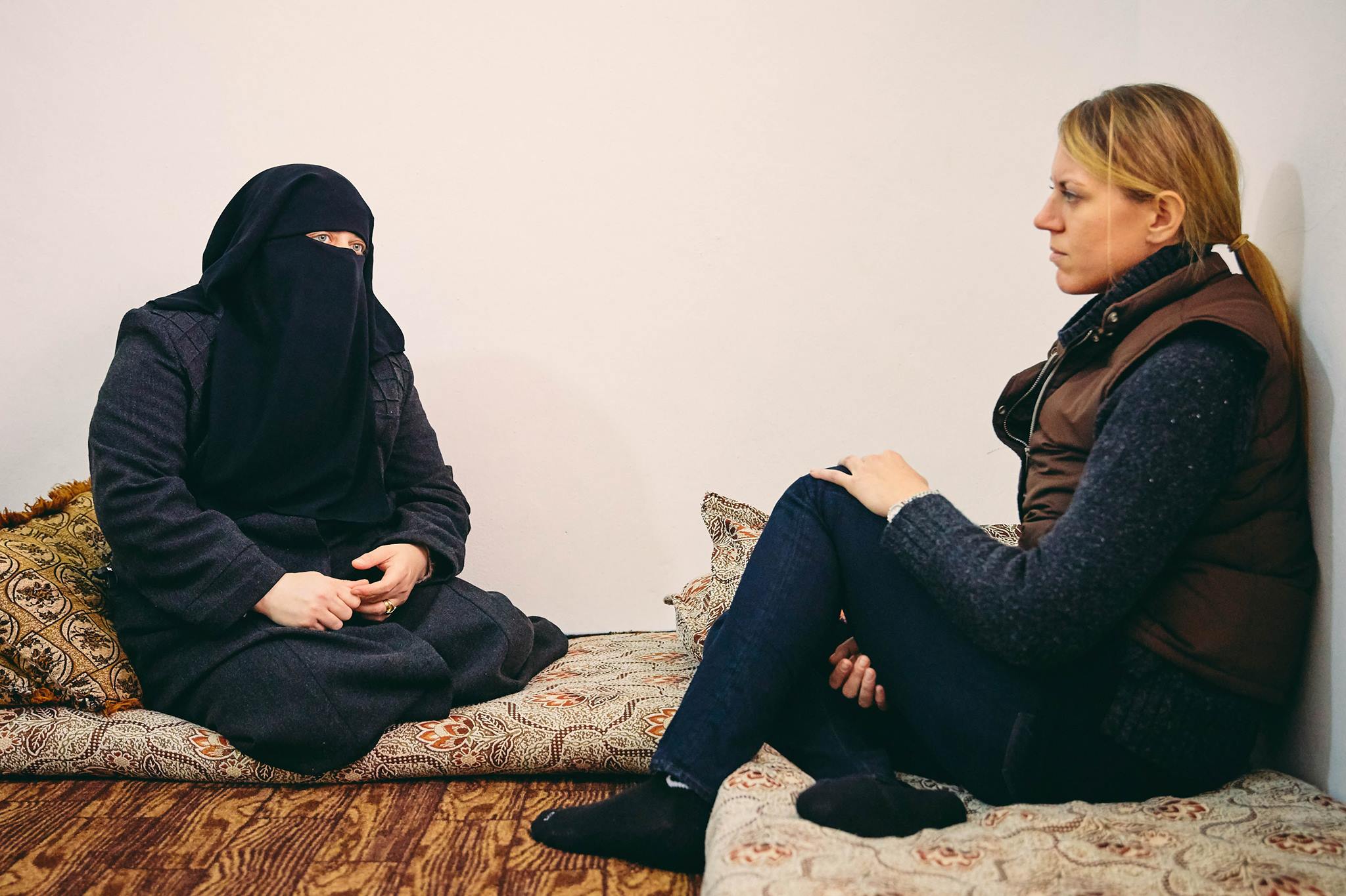 Diplomatic Language Services staff member talks with female Syrian refugee