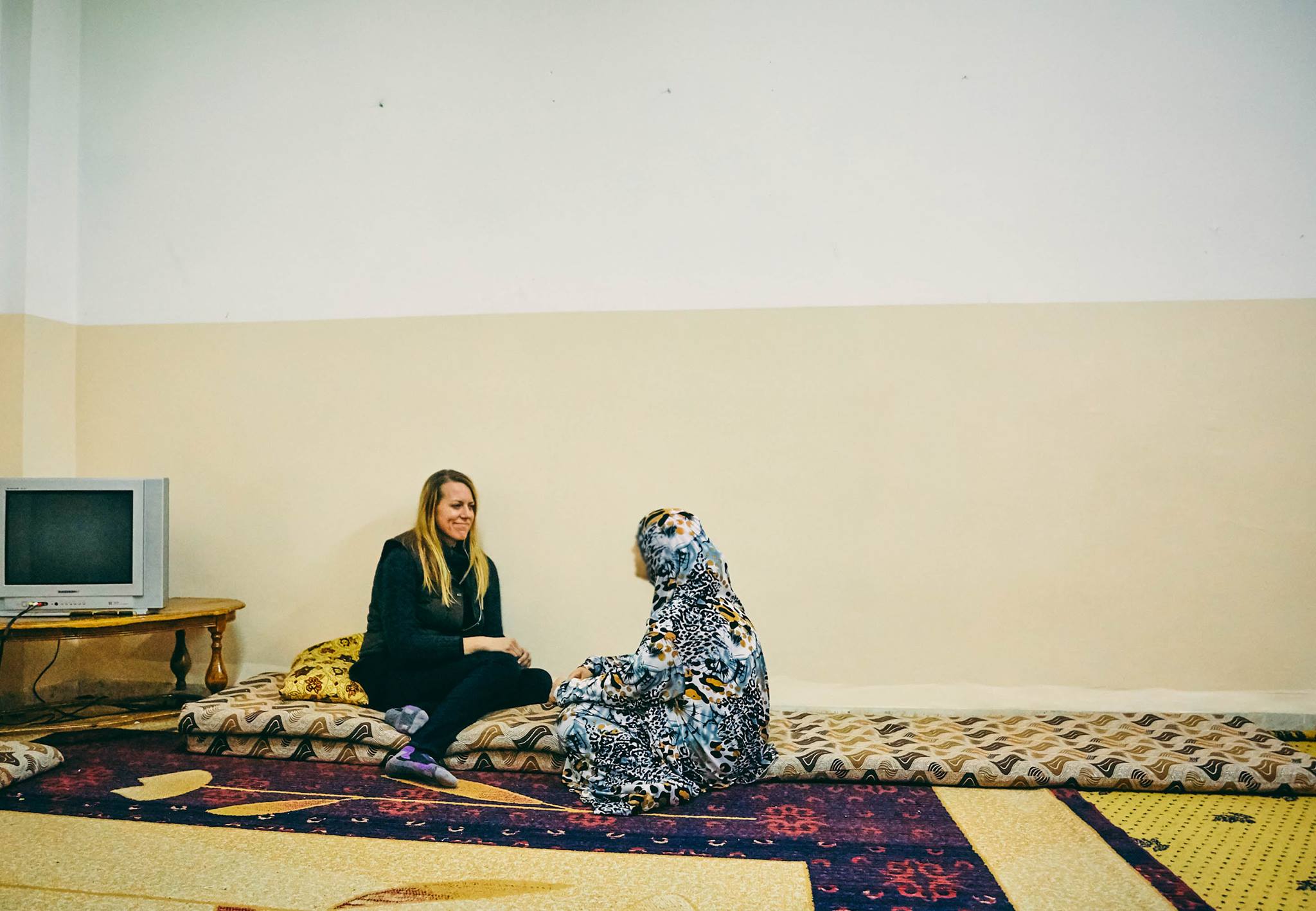 Diplomatic Language Services staff member talks with female Syrian refugee and member of Love For Syria